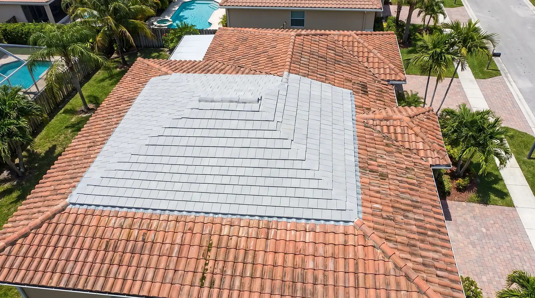 A replaced roof section of new tile meeting the older surrounding tile