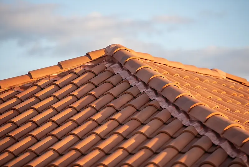 Barrel tile roof ridge on a South Florida home, late afternoon light