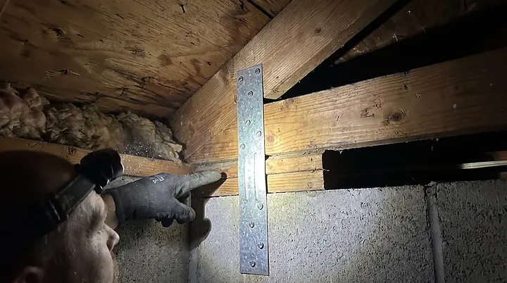 Hurricane strap wrapped over a roof truss and nailed into the block wall